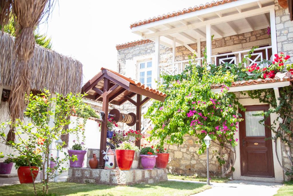uma casa com vasos de plantas em frente em Taşdelen Hotel em Alacati