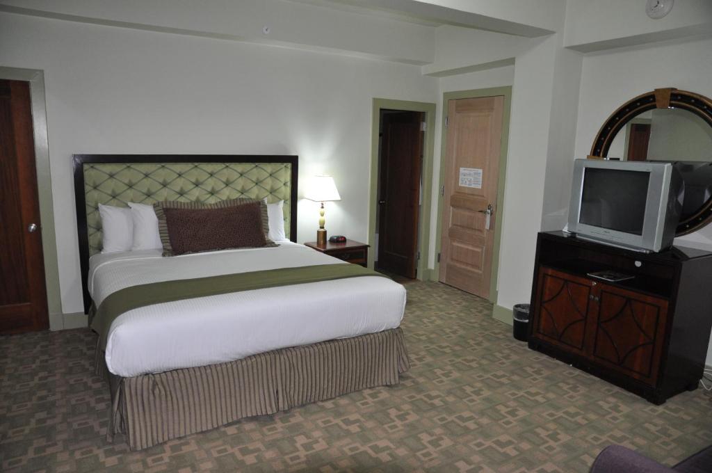 a hotel room with a bed and a tv at The Murray Hotel in Silver City