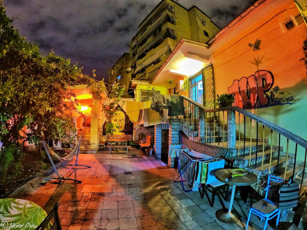 un balcone di un edificio con tavoli e sedie di Milingona City Center Hostel a Tirana
