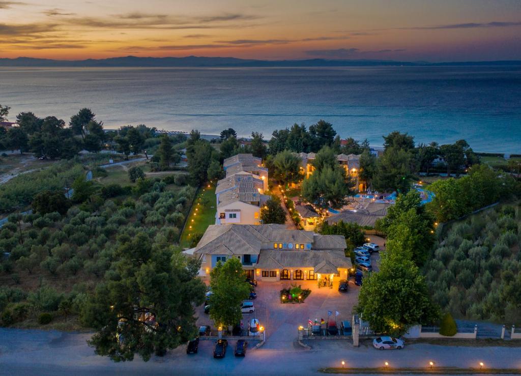 una vista aérea de una casa con el océano en el fondo en Lesse Hotel, en Chaniotis