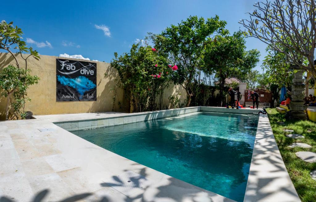 a swimming pool in the yard of a house at Bali Fab Dive Center in Amed