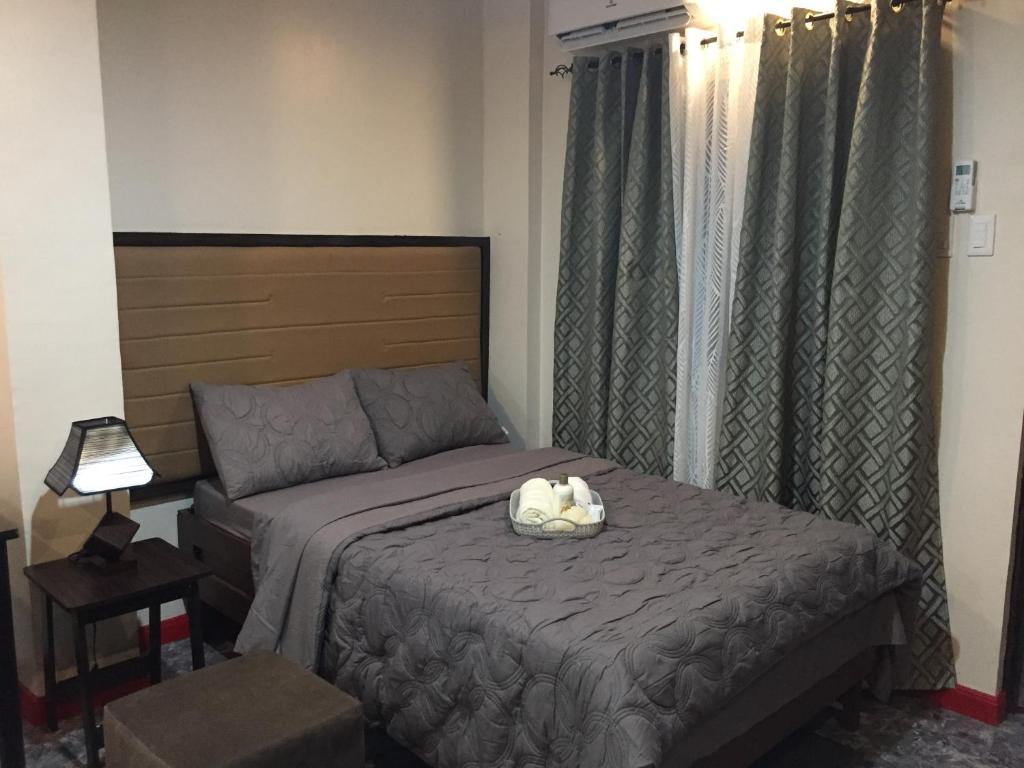 un dormitorio con una cama con un animal de peluche en MIRASOL Residences, en Daet