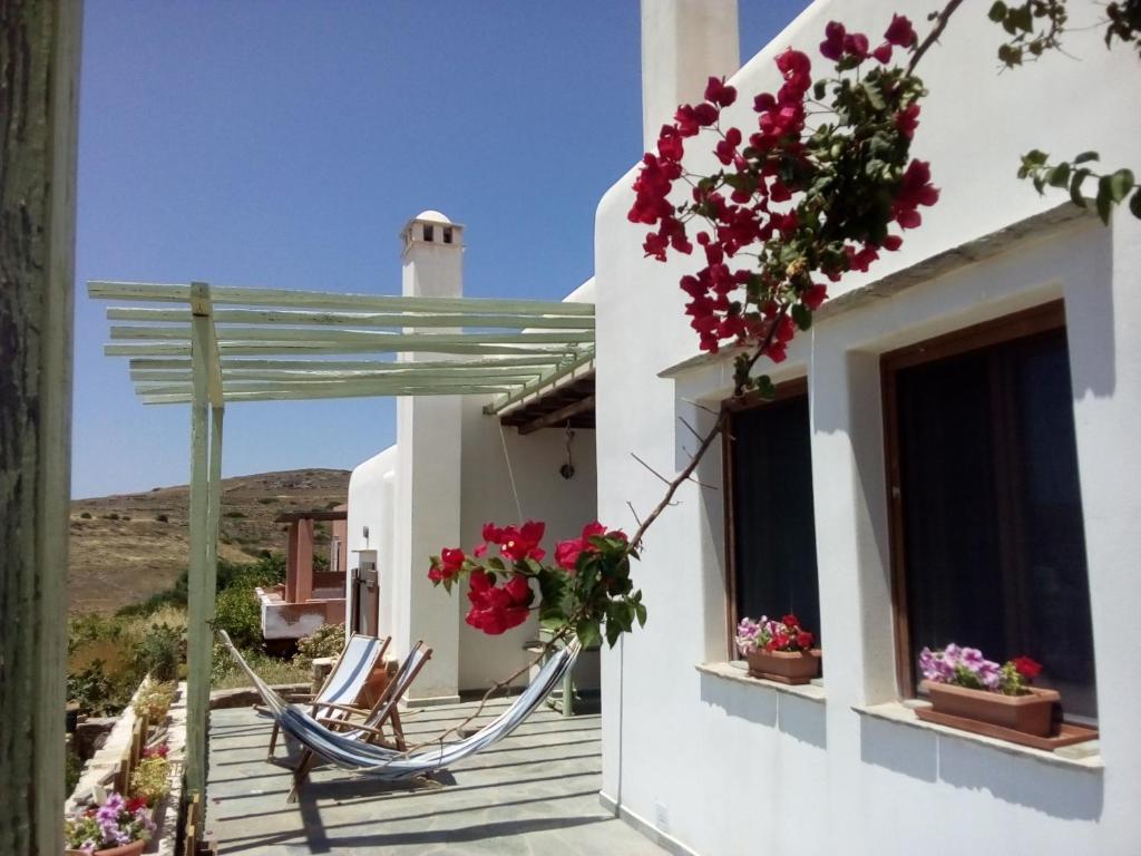 a porch with flowers and a hammock on a house at Cycladic House in Vári