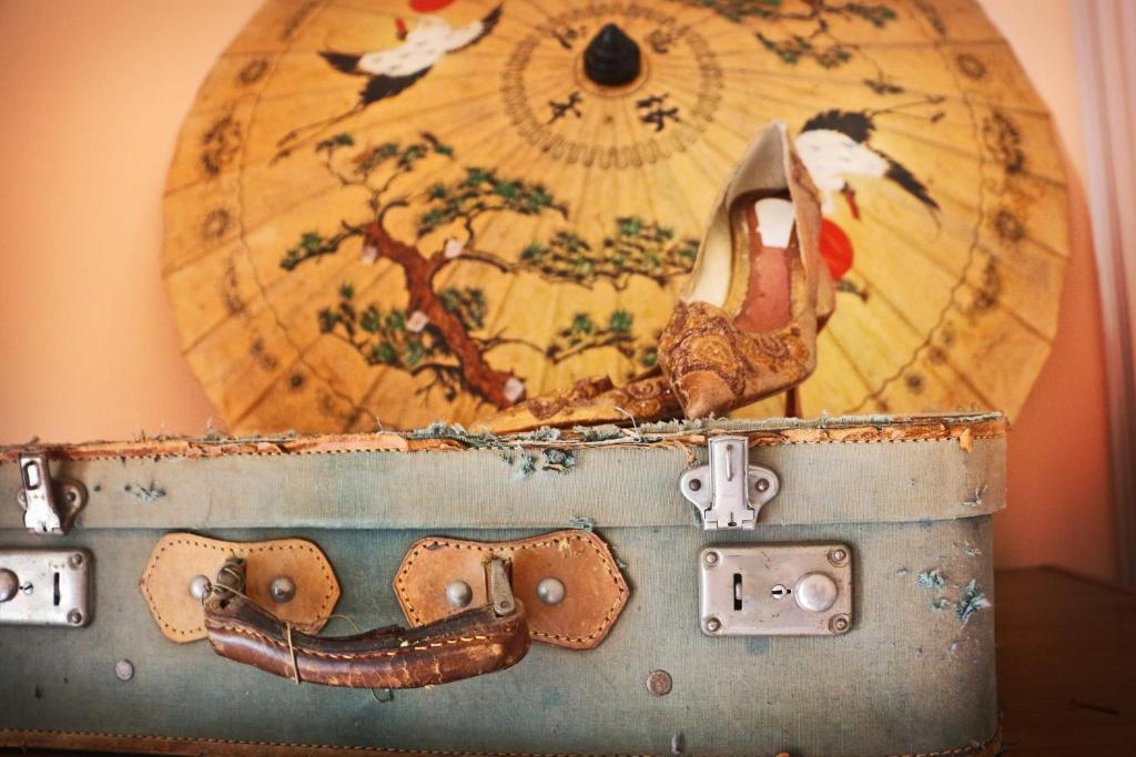 uma mala velha com um sapato em cima dela em Casa Verdi - House of Travelers em Catânia