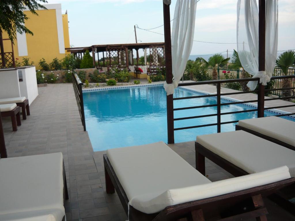 a resort with a swimming pool and some chairs at Victory Apartments Hotel in Samothráki