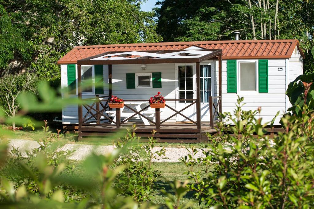 a small white house with a red roof at Mobile Homes Dvor in Manjadvorci