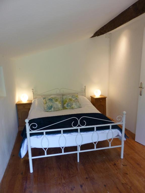 a white bed in a room with two night stands at Hameau de Montcabirol - Foix in Mirepoix