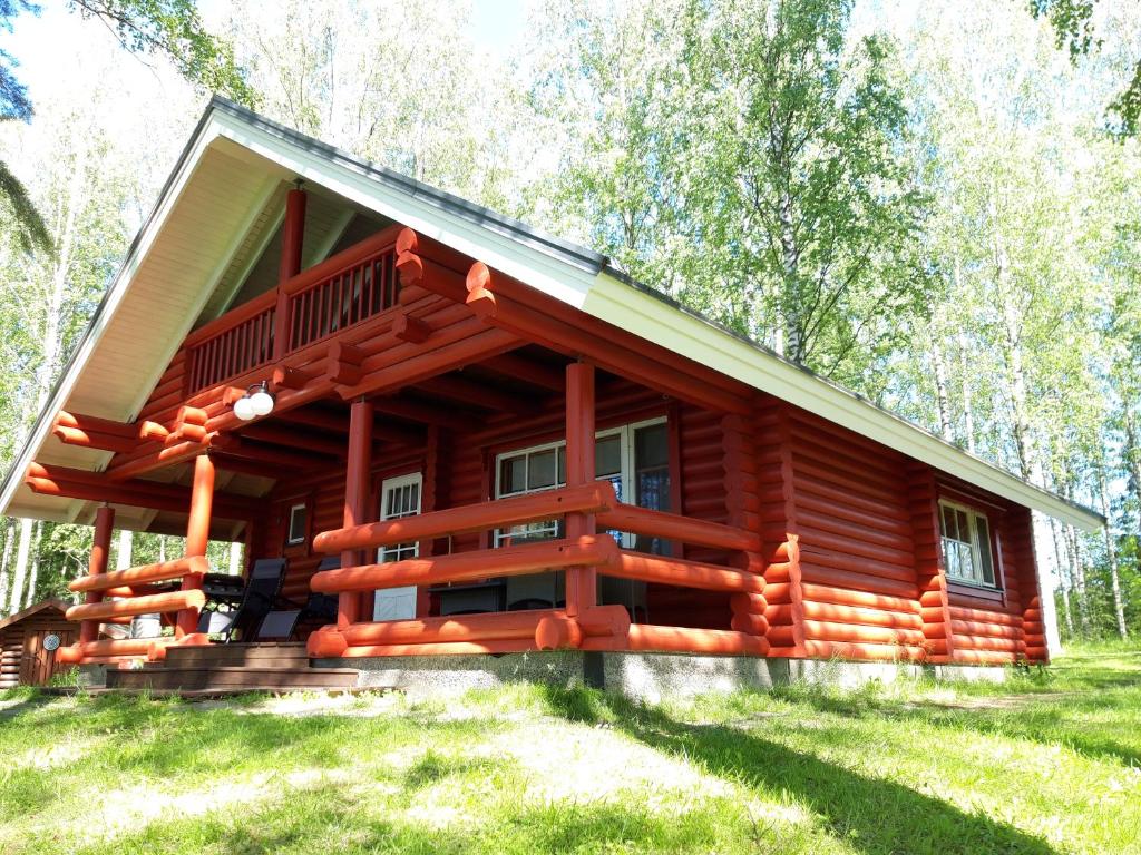 une cabane dans les bois avec une grande véranda dans l'établissement Koivuranta, à Pihtipudas