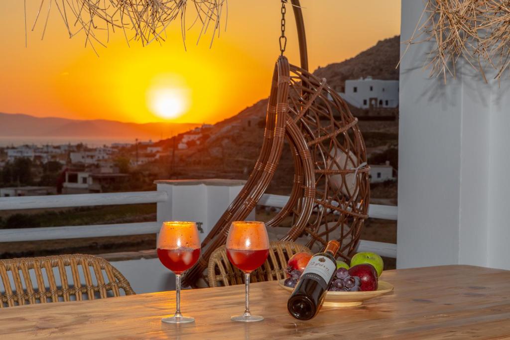 a table with two glasses of wine and a basket of fruit at Naxian Pearl in Mikri Vigla