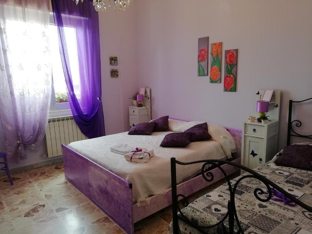 a bedroom with a purple bed and purple curtains at Casa della nonna in Riposto