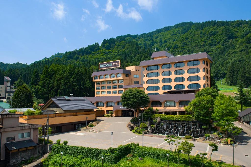 un hôtel avec une montagne en arrière-plan dans l'établissement Yuzawa Grand Hotel, à Yuzawa