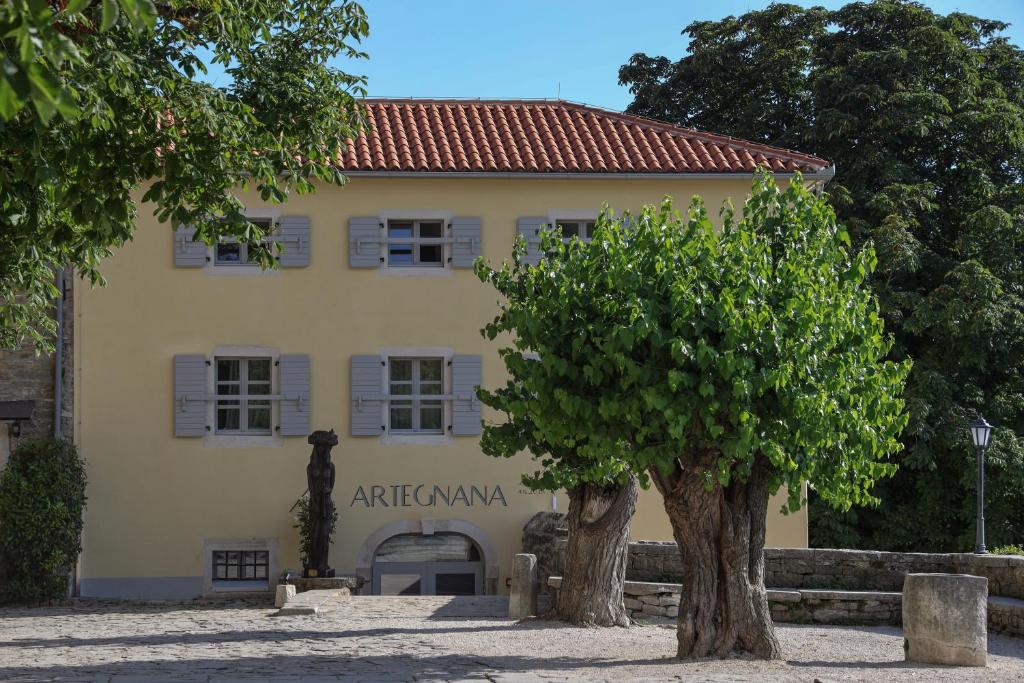 un edificio con un árbol delante de él en B&B Artegnana 1798 en Grožnjan