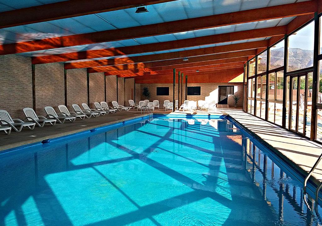 a large swimming pool with chairs in a building at Las Montañas de Olmué Resort & Conference Center in Olmué