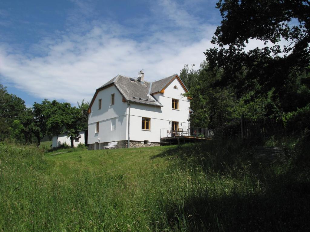 una casa blanca en una colina en un campo en Apartmány na hájovně, en Jeseník