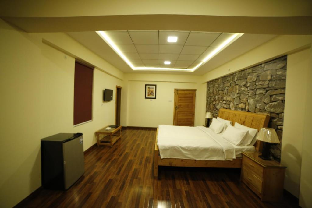 een slaapkamer met een bed en een stenen muur bij Chinar Resorts in Bāla Pīr Ziārat