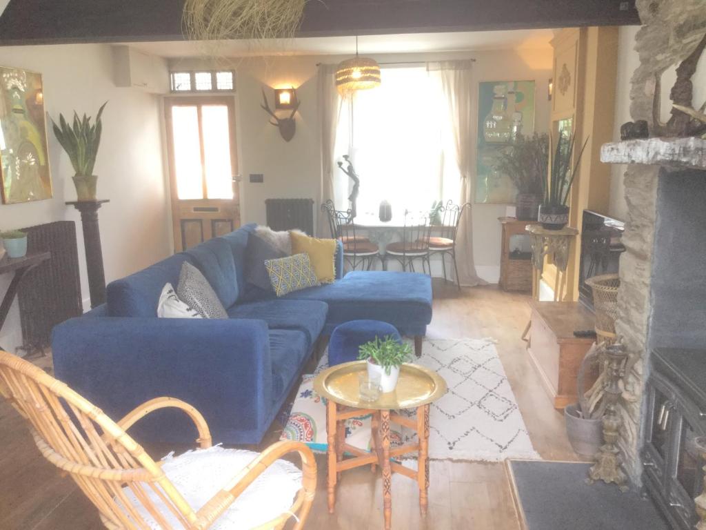 a living room with a blue couch and a table at Bambu Cottage in Newquay