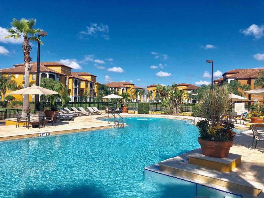 a pool at a resort with chairs and umbrellas at Serenata Condominiums,Sarasota in Sarasota