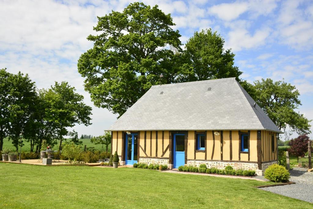 une petite maison avec un toit en gambrel dans l'établissement GITE "COTE JARDIN", à Vannecrocq