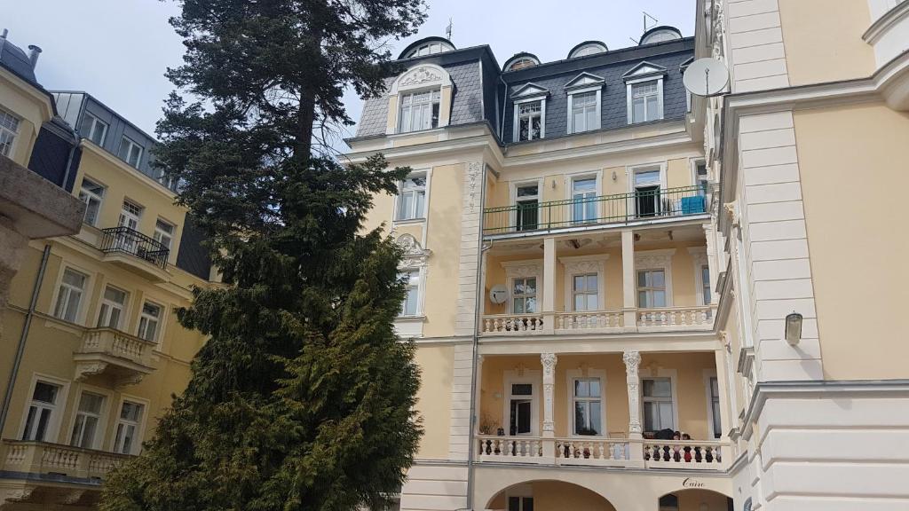 un grand bâtiment jaune avec une horloge. dans l'établissement Apartmán U kolonády, à Mariánské Lázně