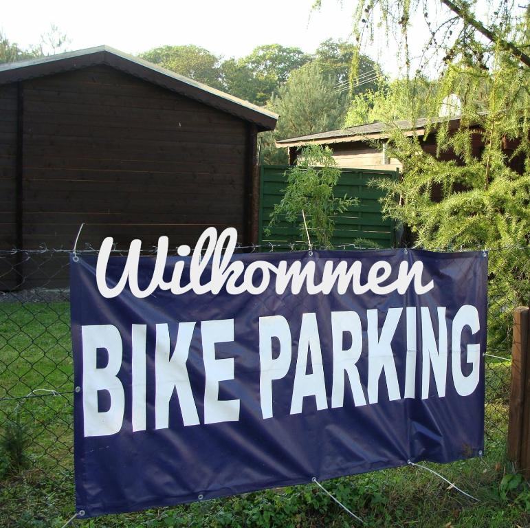 a blue and white bike parking sign on a fence at Bike Camping in Przewóz