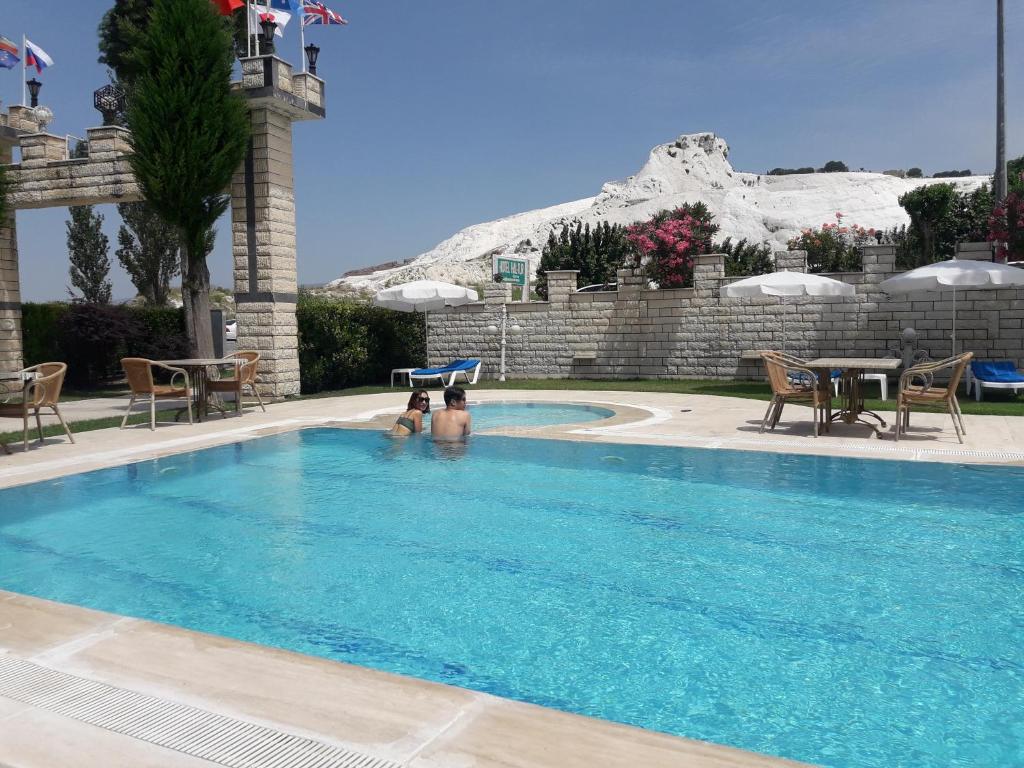 a swimming pool with a mountain in the background at Hotel HAL-TUR in Pamukkale