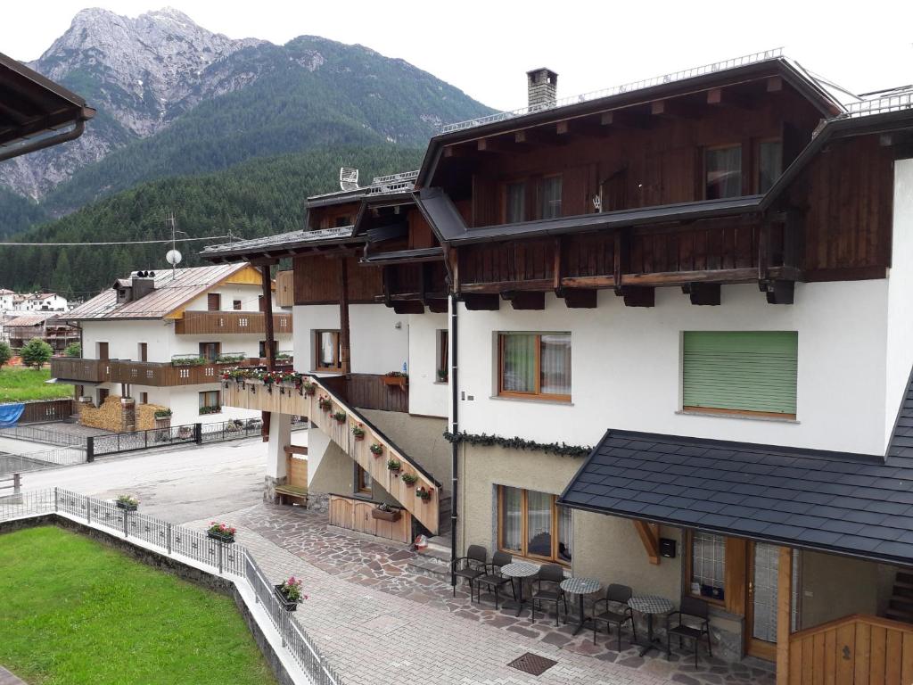 eine Gruppe von Gebäuden mit Bergen im Hintergrund in der Unterkunft Locanda Da Pierina in Santo Stefano di Cadore