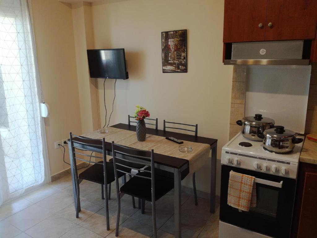 a small kitchen with a table and a stove at Jordan's Neoi Epivates Appartment by the Beach in Neoi Epivates