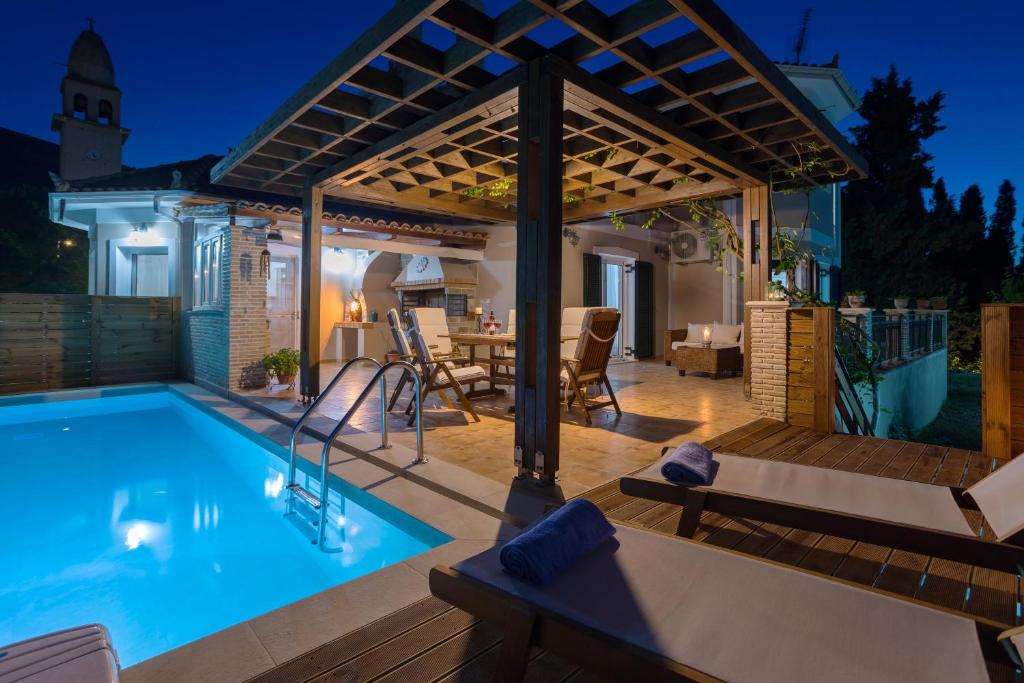 una piscina con pérgola en una terraza en Ethereal Villa, en Mouzákion