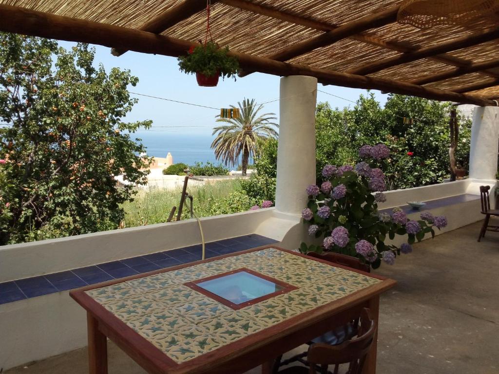 a table on a porch with a view of the ocean at Angel home in Malfa
