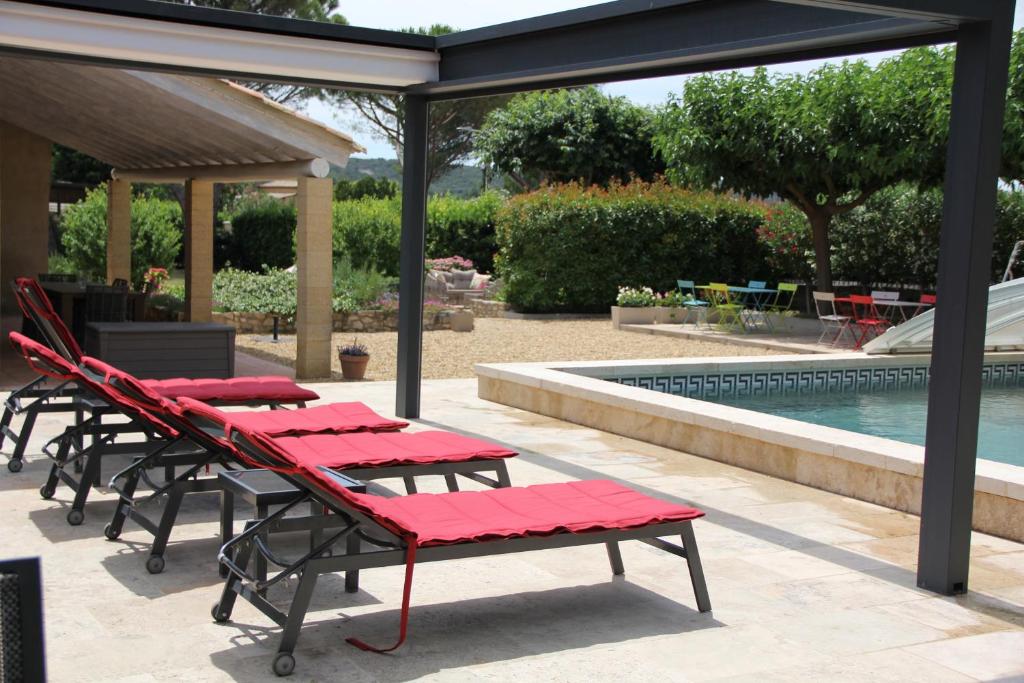 - un groupe de tables et de chaises à côté de la piscine dans l'établissement Clos de la Madone, à Flaux