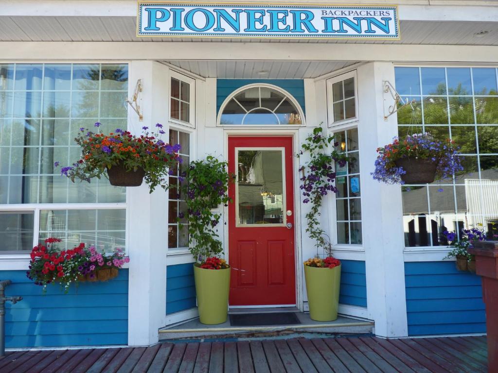 a front door of a flower inn with potted plants at Pioneer Inns in Prince Rupert