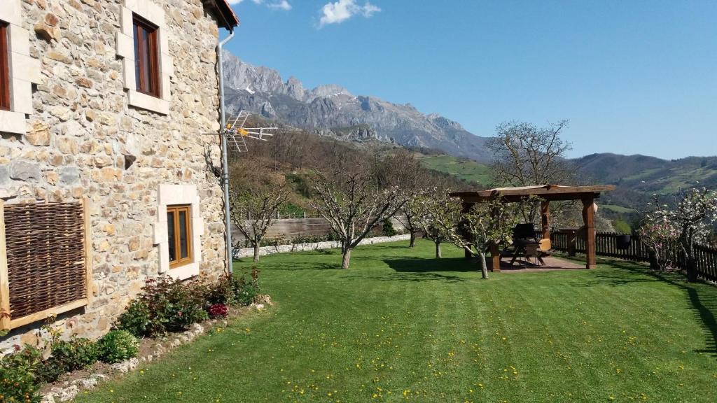 a garden with a stone building and a gazebo at CASA TERESA in Camaleño