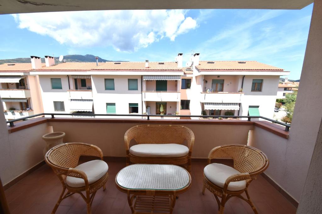 einen Balkon mit Stühlen und Tischen und Blick auf ein Gebäude in der Unterkunft AGAVE in Marina di Campo