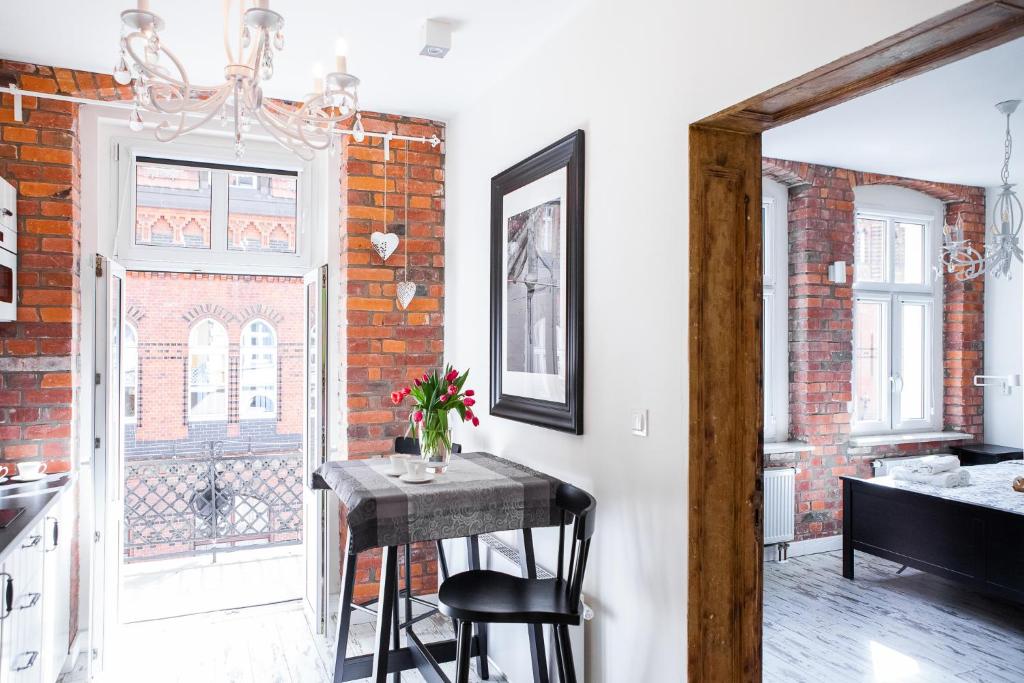 a kitchen with a table and a brick wall at Apartamenty Pocztowa in Bydgoszcz