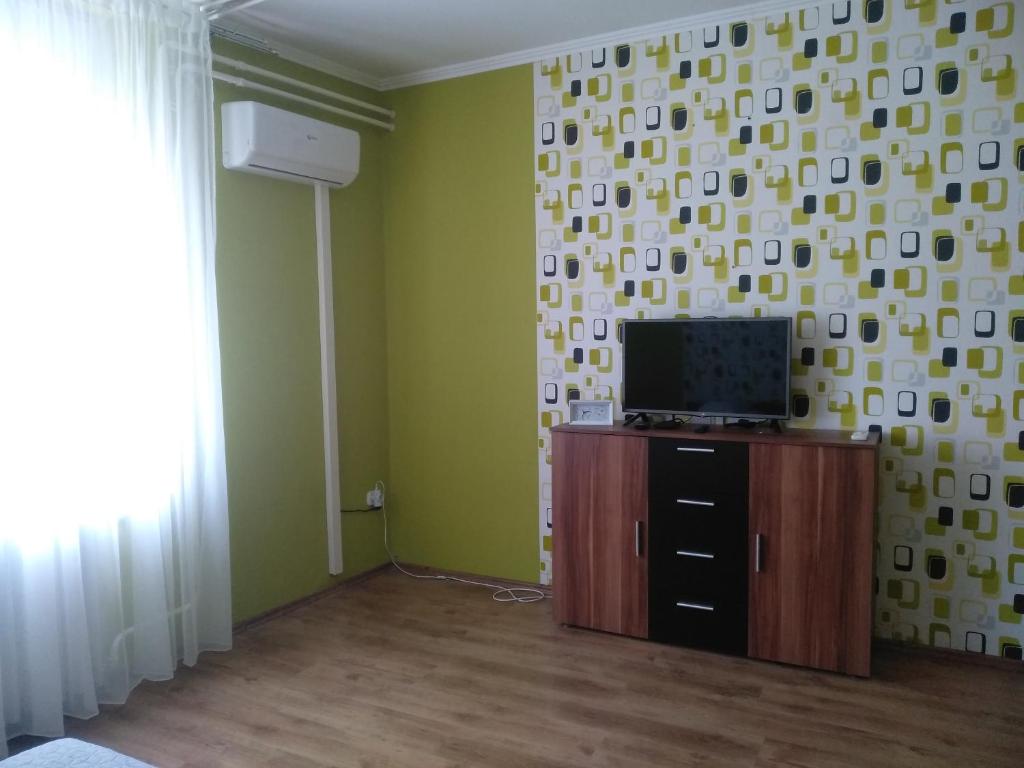um quarto com uma televisão num armário e uma parede em Inna Apartman em Hévíz