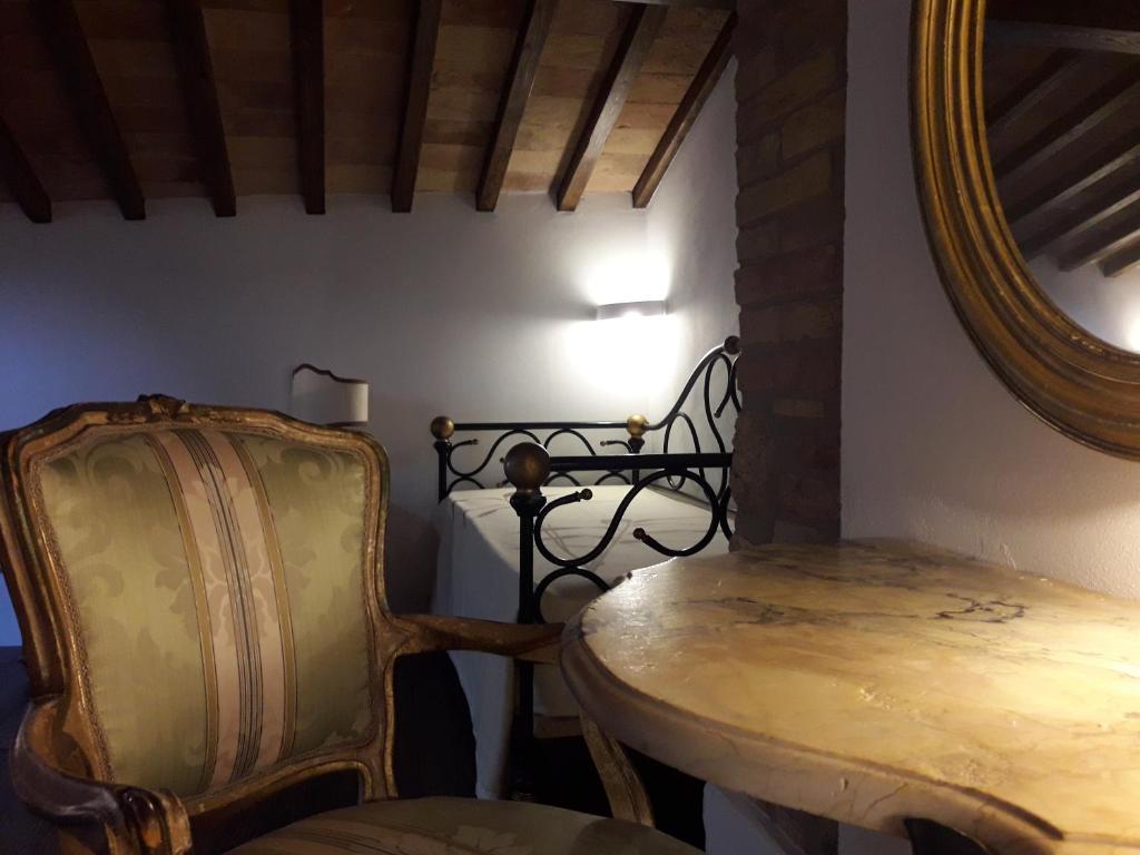una stanza con tavolo, sedia e specchio di CASA DEL MEDIOEVO a San Gimignano