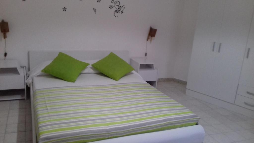 パリヌーロにあるI Faraglioniの白い部屋のベッド(緑の枕付)