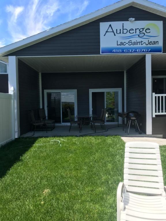 a patio with chairs and a bench in front of a building at Auberge Lac St-Jean Phase 2 in Roberval