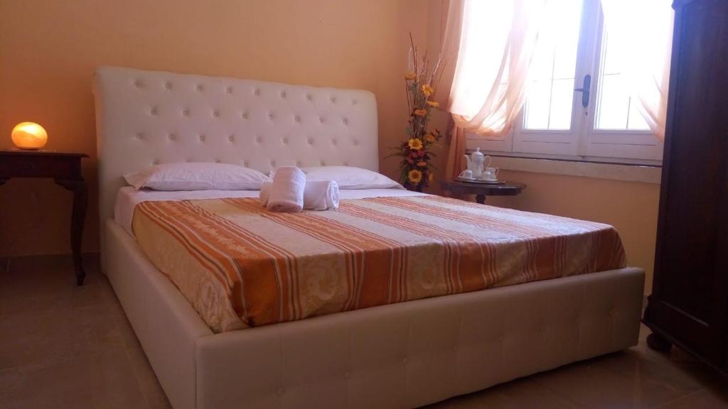 un letto bianco con due asciugamani sopra in una camera da letto di B&B Scipponate a Collepasso