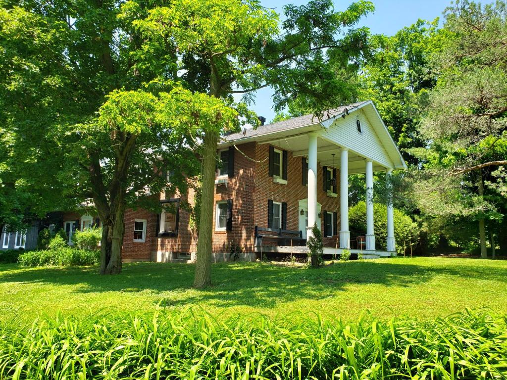 una vecchia casa in mattoni con alberi nel cortile di Auberge du Vignoble Bromont a Bromont