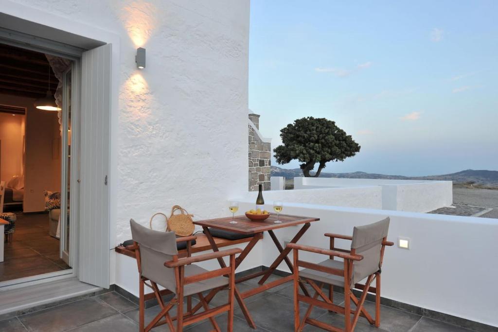 Un comedor con mesa y sillas en un balcón. en Kalivitis Boutique House, en Zefiría