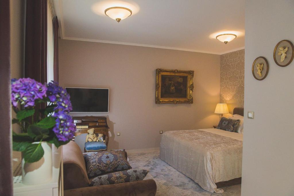 um quarto com uma cama e um vaso de flores roxas em Luxury Apartment Padre Pio em Split