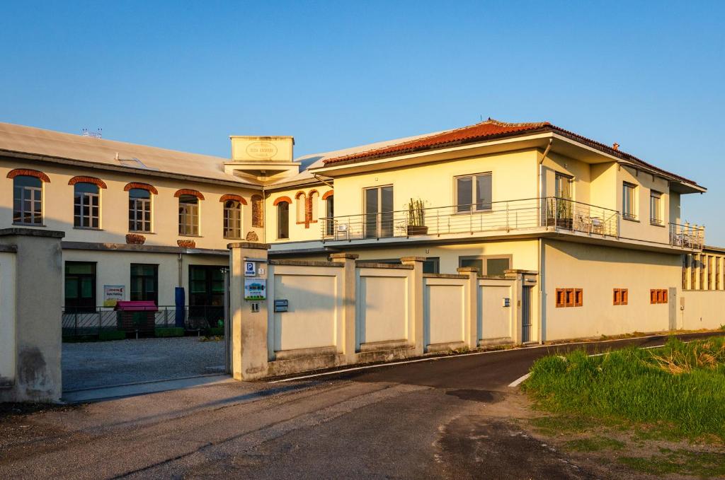 un gran edificio blanco con una puerta y una valla en La Montrucca Camere, en Caselle Torinese