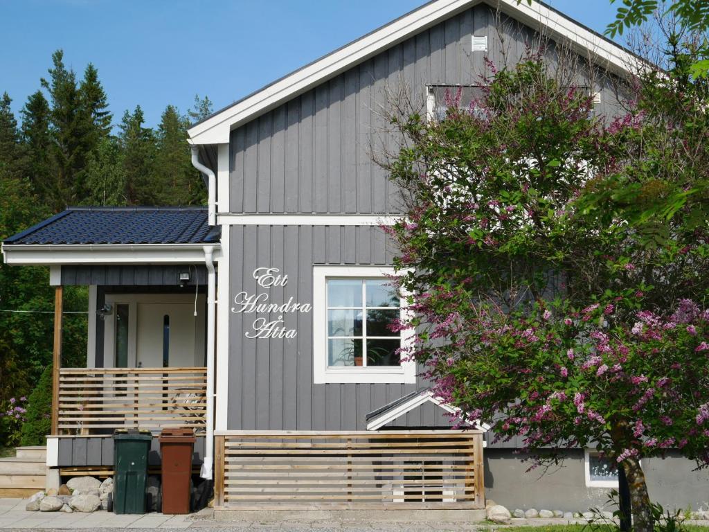 una casa gris con una ventana blanca y un árbol en Villa utanför Örnsköldsvik, Höga Kusten en Örnsköldsvik