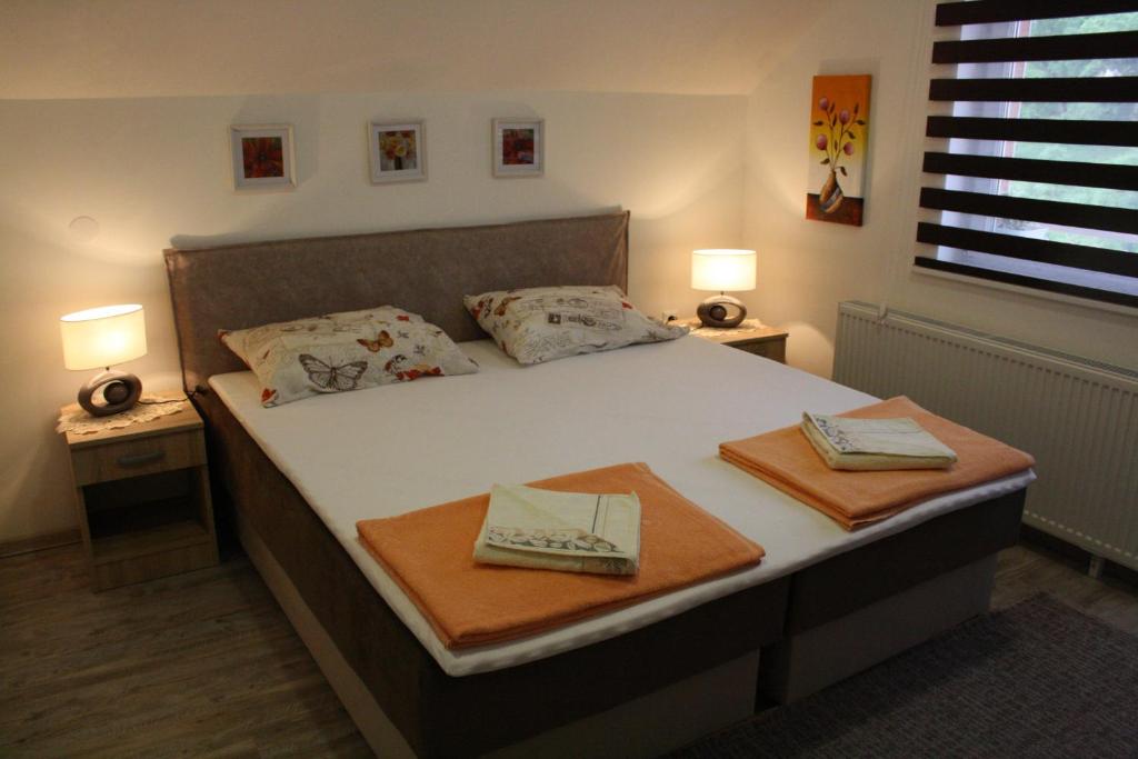 a bedroom with a bed with two towels on it at Apartmani Nikolic in Višegrad