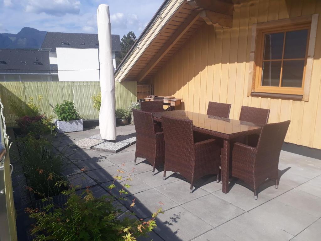 patio ze stołem i krzesłami na tarasie w obiekcie Ferienwohnung Grimmingblick w mieście Bad Mitterndorf