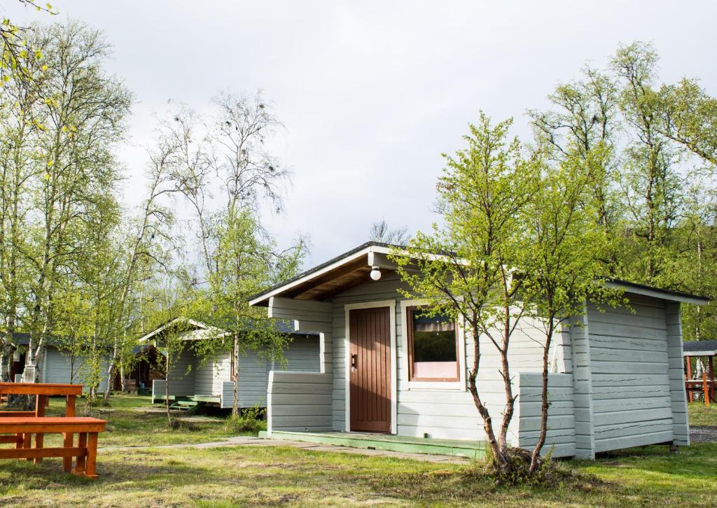 una pequeña casa con una mesa de picnic delante de ella en Vetsikon Leirintämökit en Utsjoki