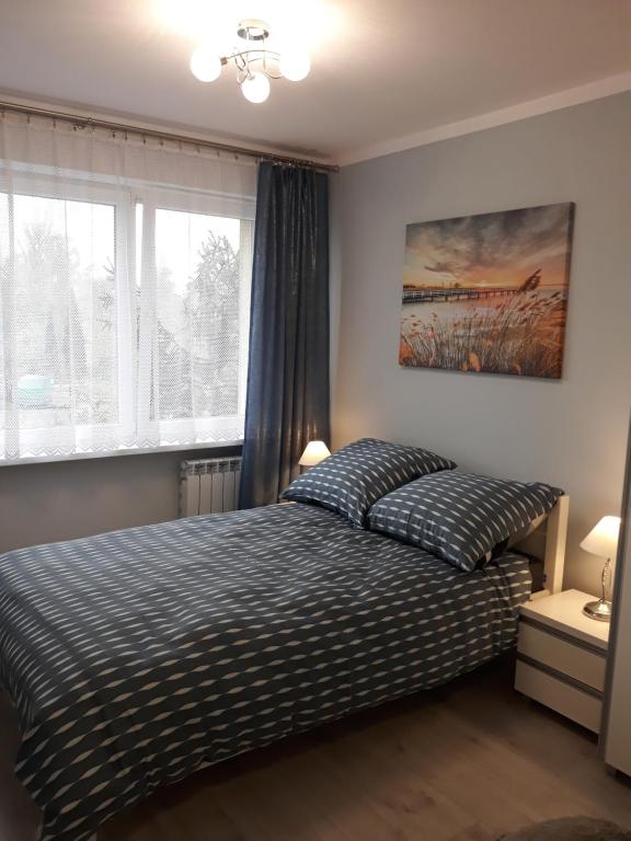 sypialnia z łóżkiem i dużym oknem w obiekcie Katrin House w Oświęcimiu