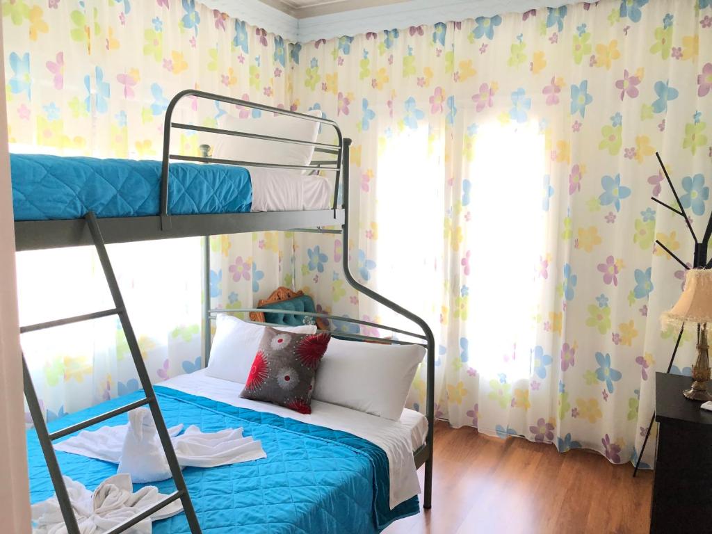 a bedroom with a bunk bed with blue sheets and flowers at Evmorfias House in Kallirakhi