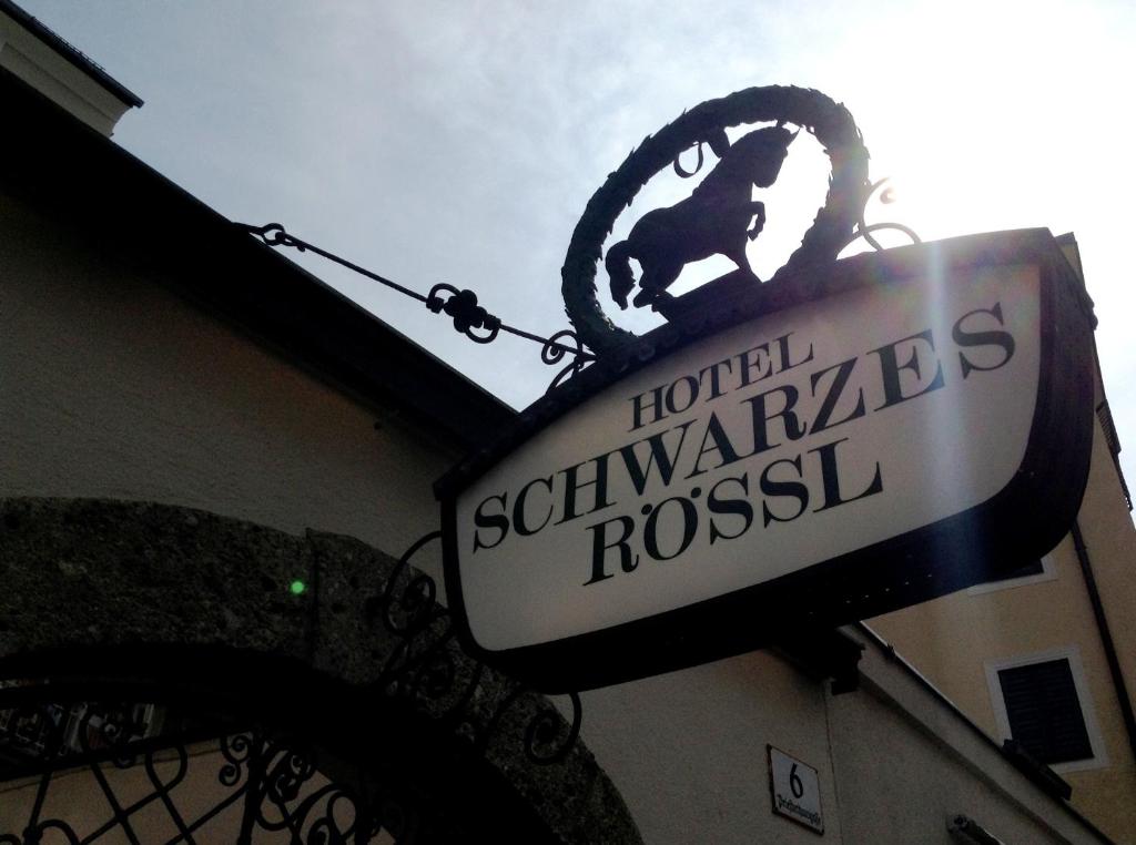 un panneau d'hôtel sur le côté d'un bâtiment dans l'établissement Hotel Schwarzes Rössl, à Salzbourg